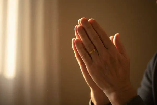 Mãos em oração, luz suave, conforto espiritual